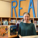 Marjorie Dowd smiles for a photo in a school library