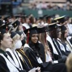 A graduate smiles for a photo during a graduation ceremony