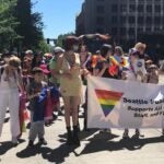 A group of students, staff, and community members walk in the PRIDE parade with SPS.