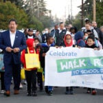 The SPS superintendent and mayor walk with students who are carrying a sign.