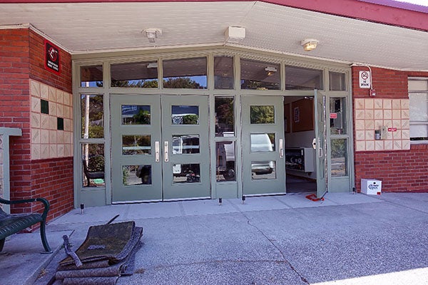 closer view of green doors in a low brick building