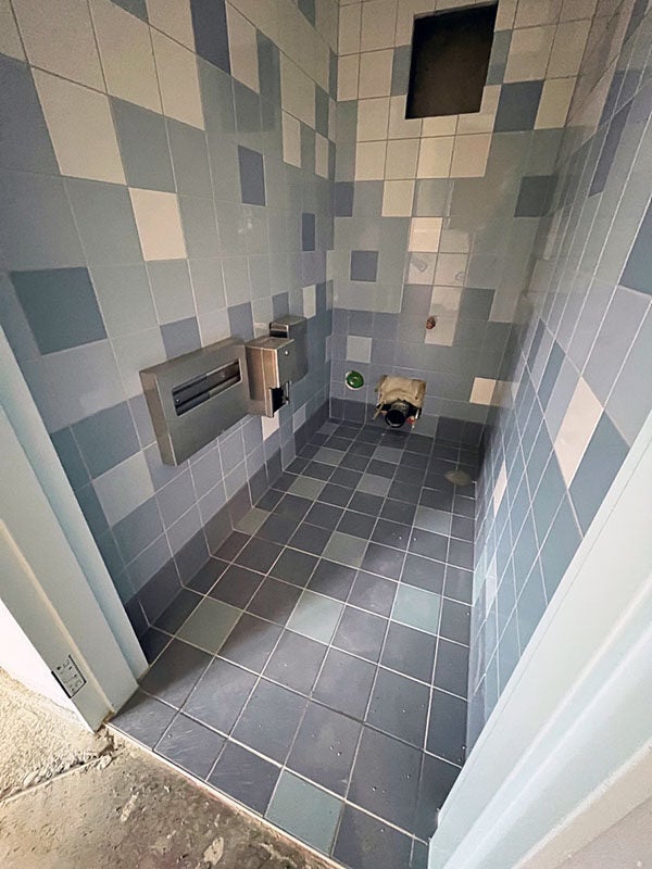 a small room has tile floors and walls