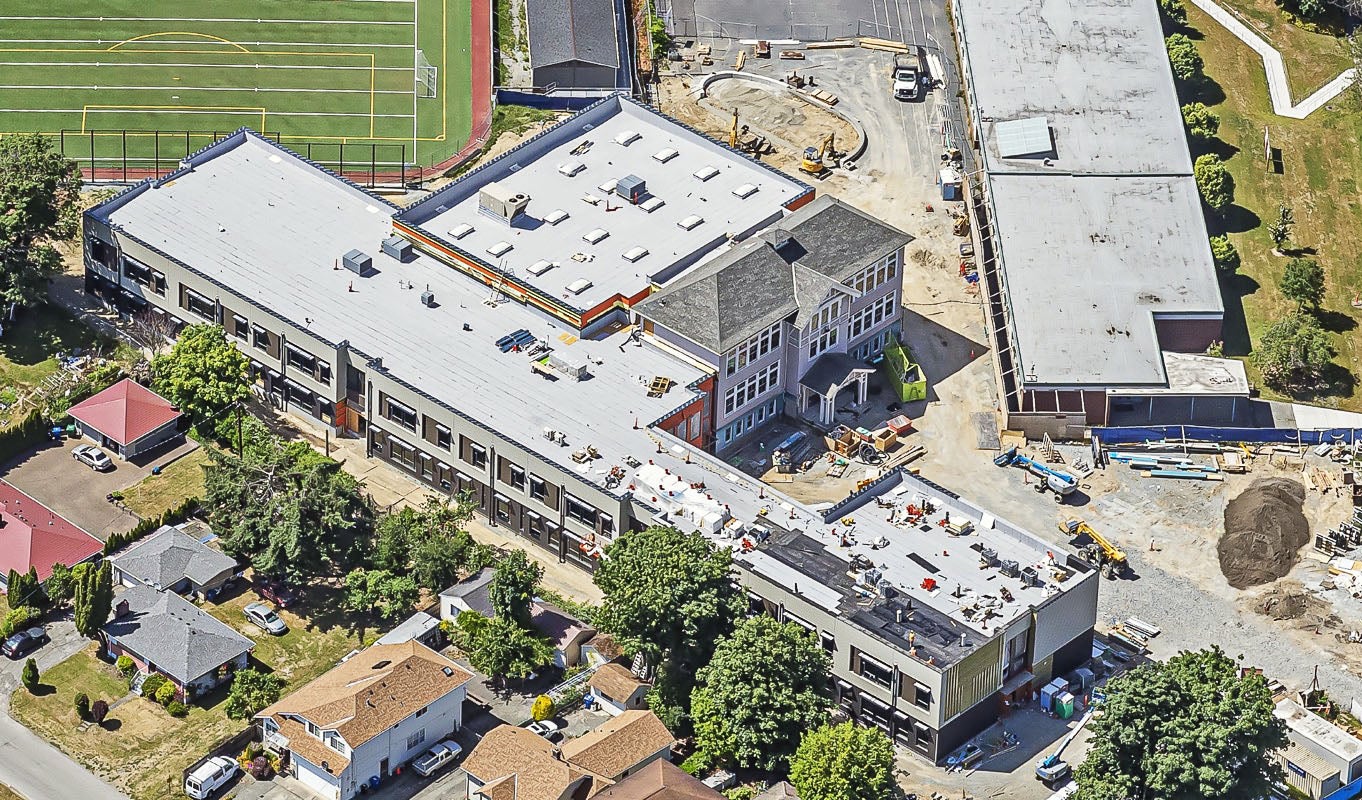 aerial view of two buildings one at a 45 degree angle to the other. construction work is going on at the building exterior