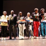 Black College Expo attendees standing on a stage.