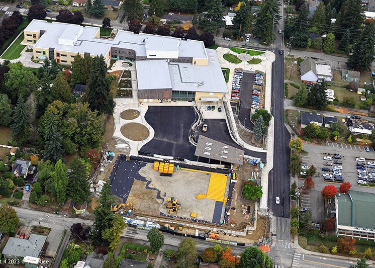 aerial view of a large building and paved areas with some construction work taking place in the lower portion