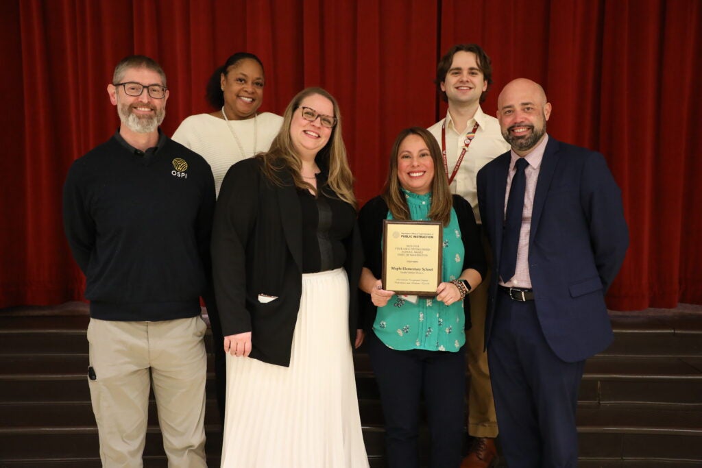 Group photo of Maple Elementary and SPS staff holding School of Distinction Award