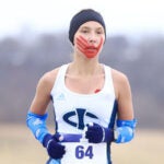 Rosalie Fish in runners gear with red paint hand print runs outside