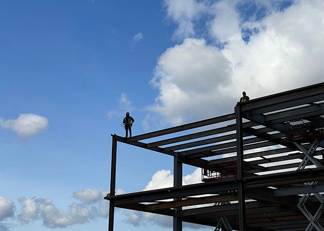 2 people stand on a steel-framed structure