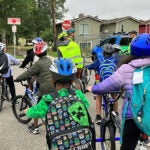 A group of students ride bikes to school.
