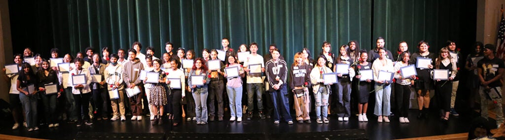 A large group of students gather for a photo in the Franklin auditorium