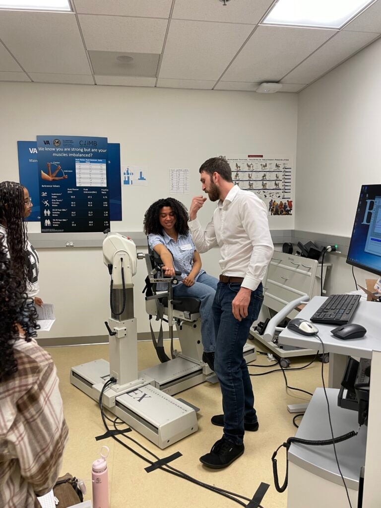 Student sits on medical chair and tests equipment