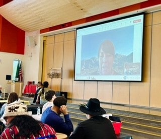 Photo of woman on screen in auditorium