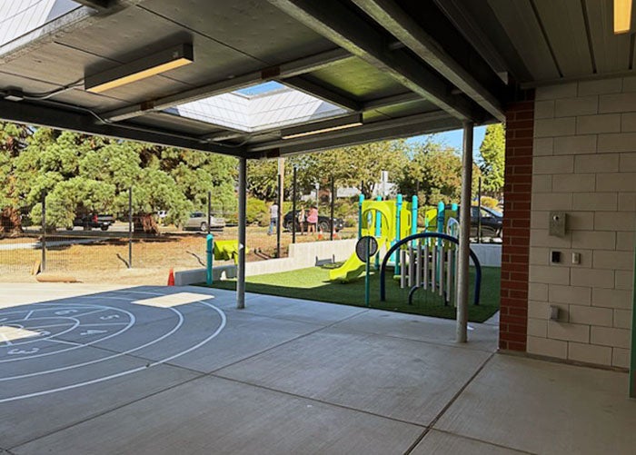 a covered area with skylights and a small playground with play equipment
