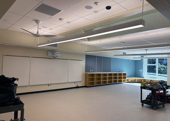 a classroom with white boards, low wall book case, and a seating window seat