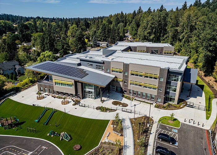 aerial of a school building with paved areas and a hill with play equipment/slides