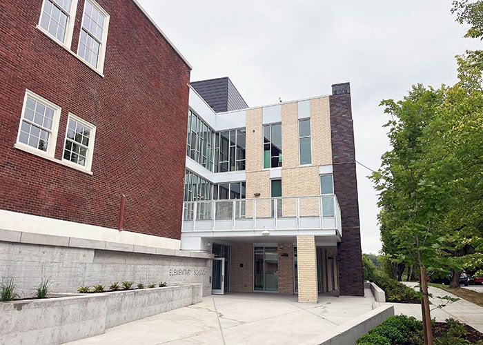 a paved area leading to doors with a balcony over them