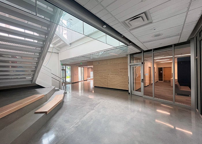 an entry lobby with stairs going up and doors to an office