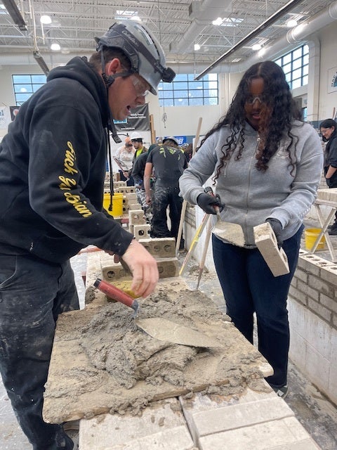 student working with cement in large warehouse