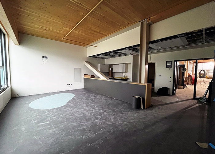 a room with a wood ceiling, a half wall, and flooring