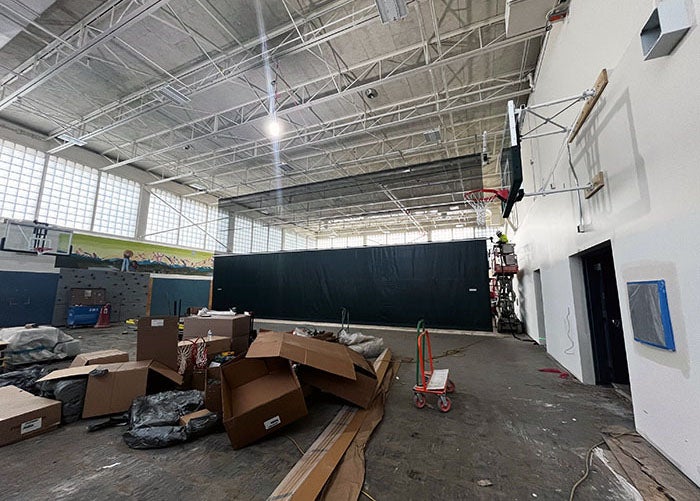 a gymnasium with construction work happening and materials spread throughout