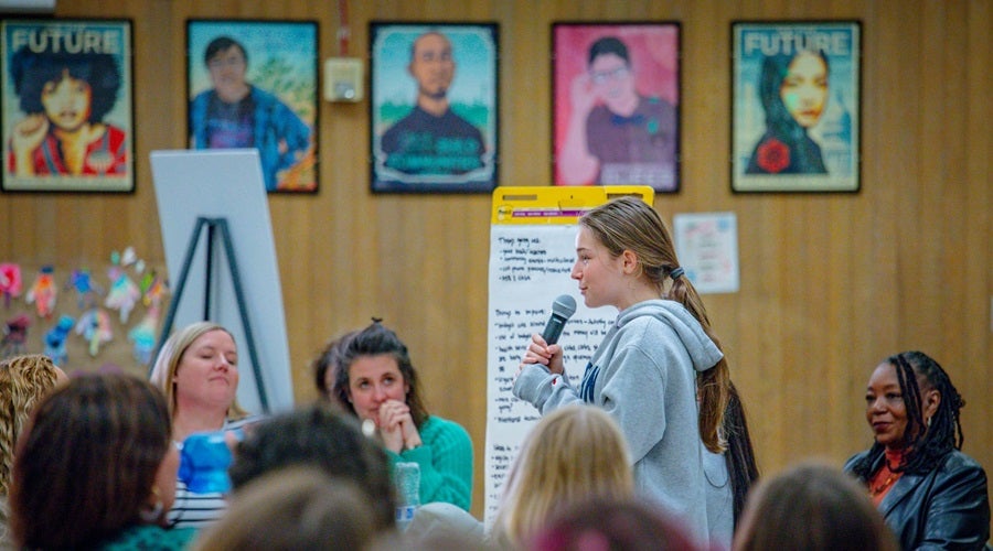 Community member presenting at a Superintendent community meeting in the Salmon Bay Cafeteria
