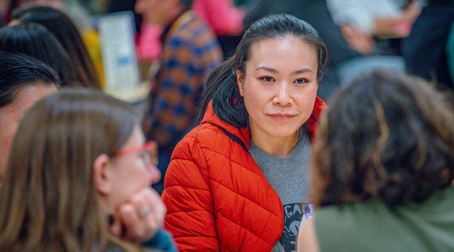 Community members talking at a table at a Superintendent community meeting in the Salmon Bay Cafeteria