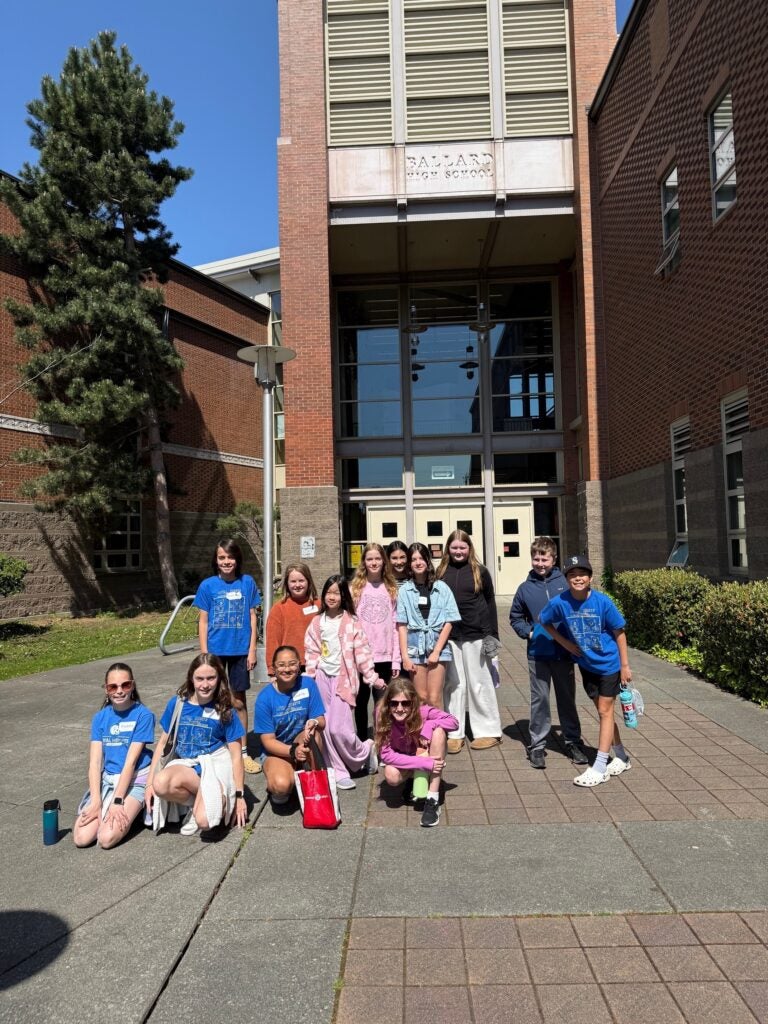 student in front of a high school