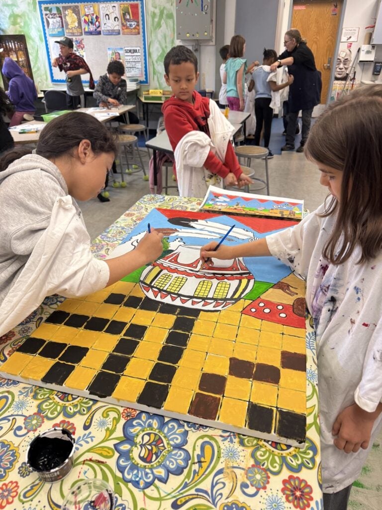 Students painting land acknowledgement mural