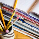 Jar of pencils and stack of notebooks