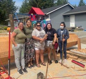 Andrea Wilbur Sigo, and a group of community members in front of a log intended to be used for a welcoming pole in Pioneer Square, Seattle, Washington