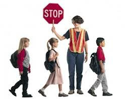 crossing guard holding stop sign while students cross the street