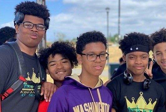 Five high school students pose for a photo together outside.