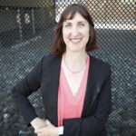 Nicole Silver standing in front of a fence.