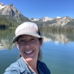 Photo of Jenn Cooper with a serene lake and mountains in the background