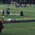 People stand on an athletic field