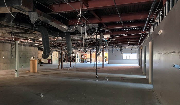 inside of a large room with ceiling tiles removed and wires hanging down