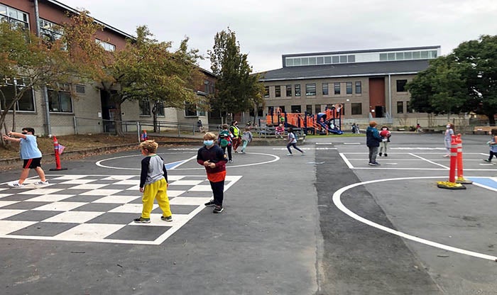 a playground with a building wrapping around two sides