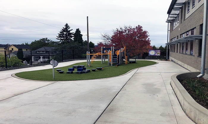 a play area on grass in the middle of concrete