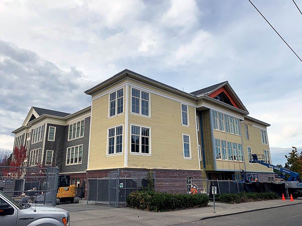 the corner of a two story building with new siding
