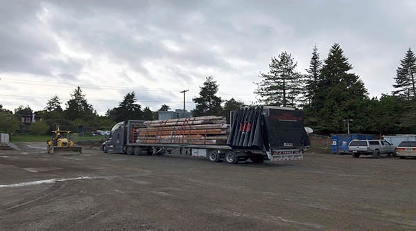 a flatbed semi truck has a load of wood and other materials on it