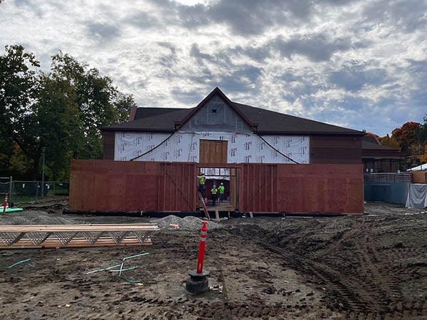 wood walls in front of an existing building with mud in front