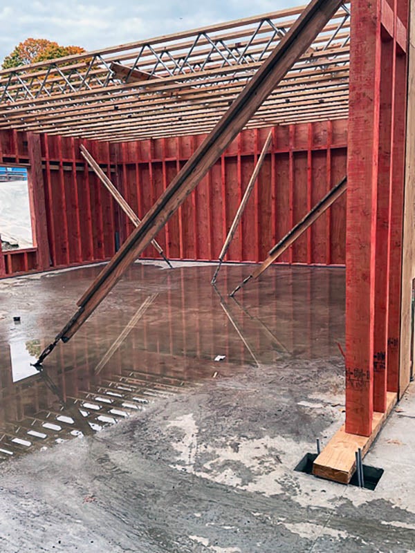 a partially framed building with a concrete floor