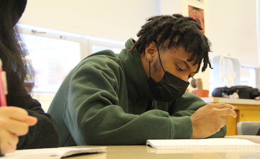 A student works on a paper in a classroom