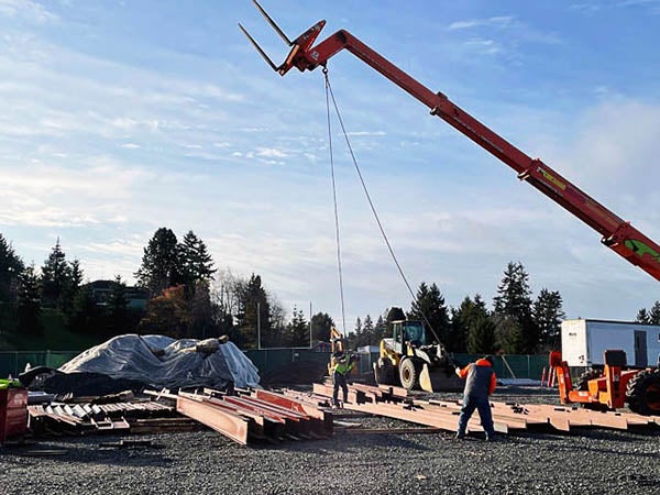 a crane is moving steel beams