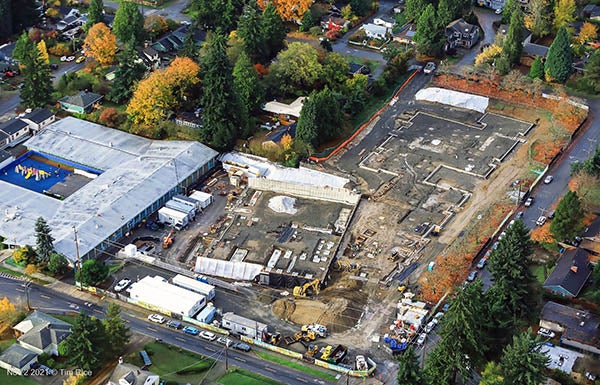 Aerial view of a construction site with a large building to the left