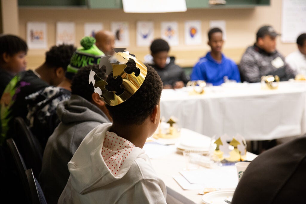 A group of student gather around a table at a meeting.