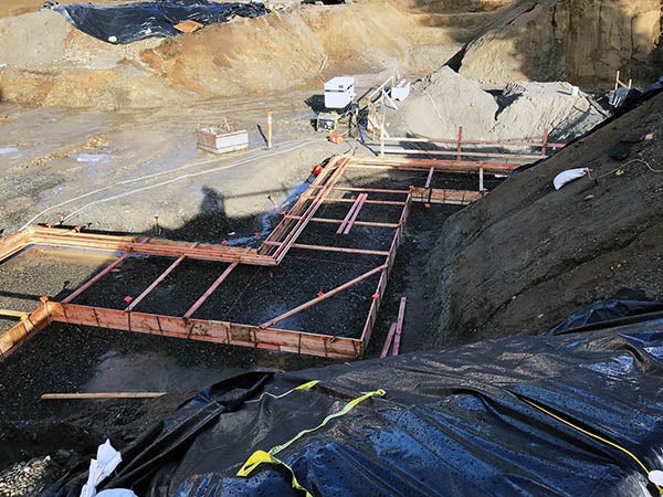 a construction site has piles of dirt surrounding forms for concrete