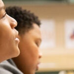 A student talks to other students in a meeting