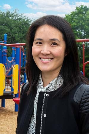 Vivian Song Maritz smiles for a photo while standing in a playground