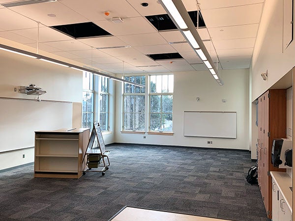 interior classroom view with windows in corner and smart board/presentation station to the left